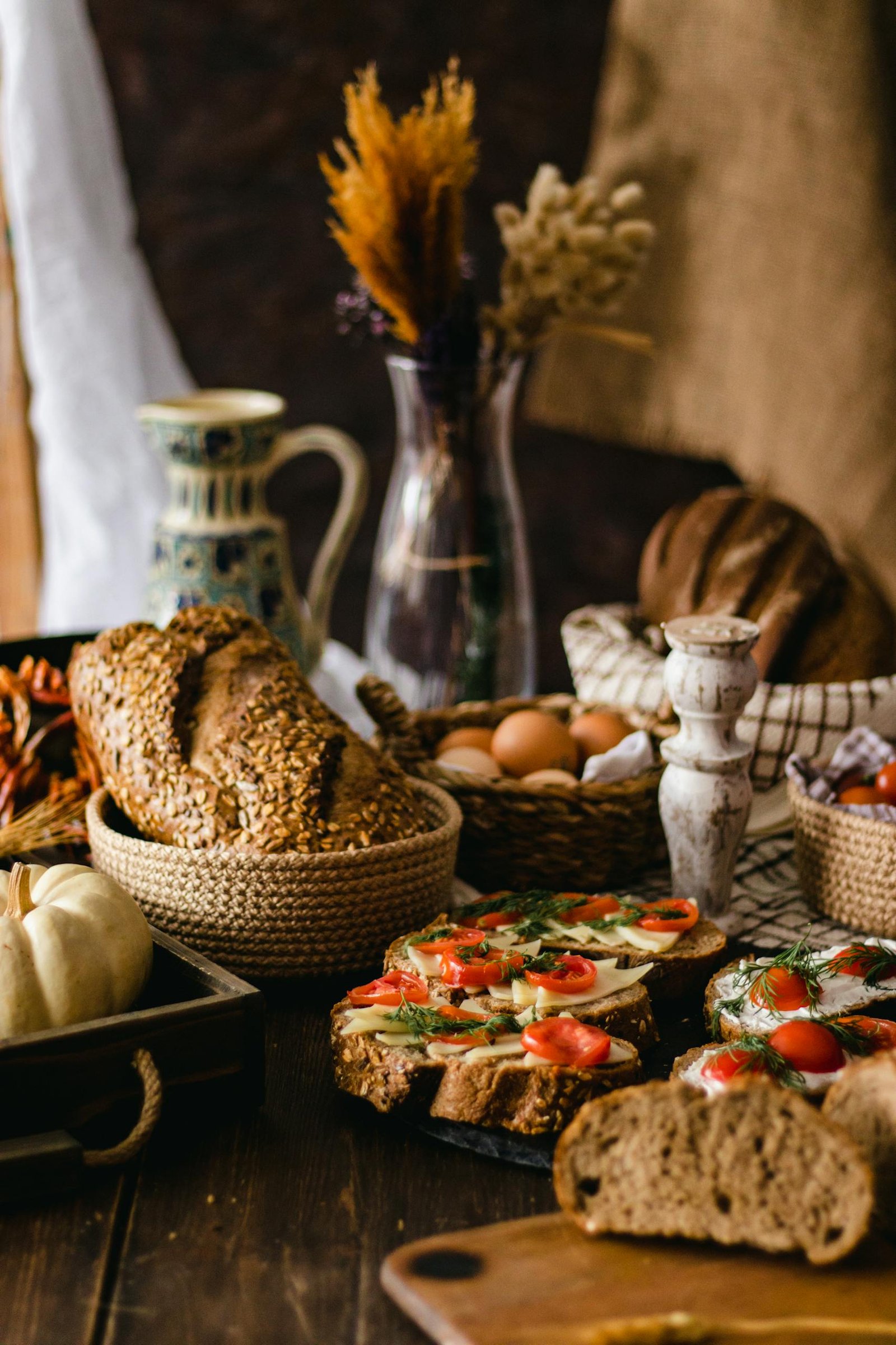 Assorted breads with vegetables and decor on a rustic table setting.